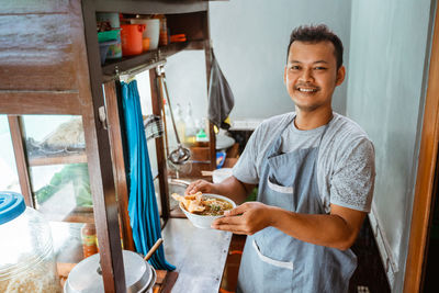 Portrait of young man preparing food at home