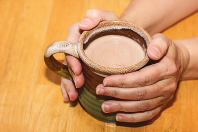 Hands holding a coffee cup diagonal