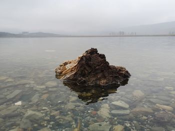 Scenic view of rocks in lake against sky