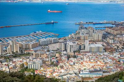 High angle view of buildings by sea against sky