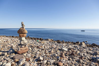 Stack of stones on beach against clear sky