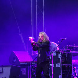 Woman with arms raised standing in front of building