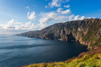 Scenic view of sea and mountains against sky