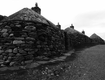 Stack of stone wall against clear sky