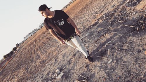 Full length of young man walking on field against sky