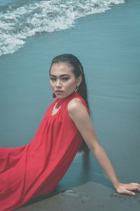 Beautiful woman sitting on shore at beach