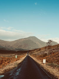 Empty road against mountains