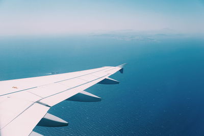 Airplane flying over sea against sky