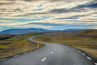 Road leading towards mountains against sky