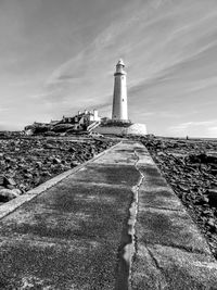 Lighthouse amidst buildings against sky