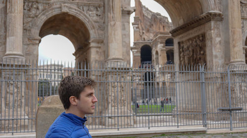 Portrait of boy standing in front of historical building