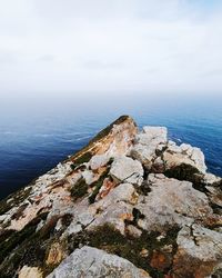 Rock formations by sea against sky