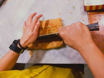 Midsection of woman cutting fried food at table