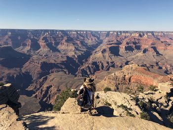 Woman standing on rock against sky