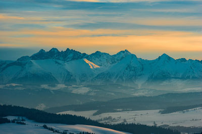 Scenic view of snowcapped mountains against sky during sunset