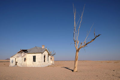 Abandoned building against clear blue sky