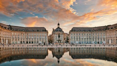 Reflection of buildings in water at sunset