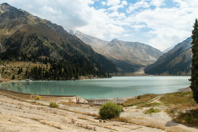 Scenic view of lake by mountains against sky