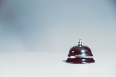 Close-up of bell on table against gray background