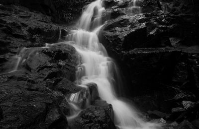 Low angle view of waterfall along rocky wall