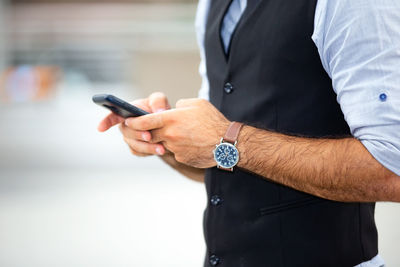 Midsection of man using phone