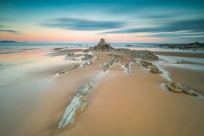 Scenic view of beach against sky during sunset