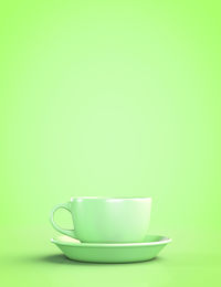 Close-up of coffee cup against green background