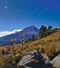 Scenic view of mountains against blue sky