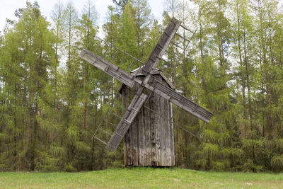 Old wooden windmill in meadow, open air. blades of mill wooden in rural eastern europe area