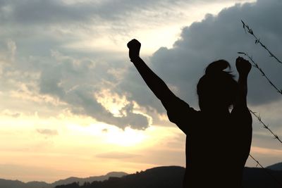 Low angle view of silhouette woman against sky during sunset