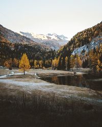 Scenic view of lake by mountains against sky