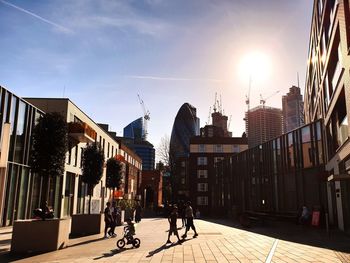 Street amidst buildings against sky on sunny day