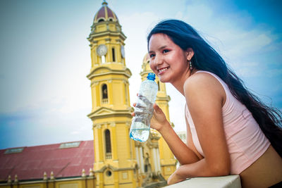 Portrait of smiling young woman in front of church