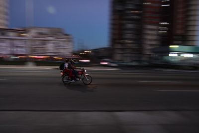 Blurred motion of man riding motorcycle on road