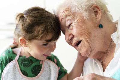 Grandmother and granddaughter resting their heads with love