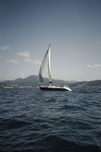 Sailboat sailing on sea against sky