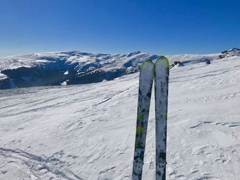 Scenic view of snow covered mountains against blue sky