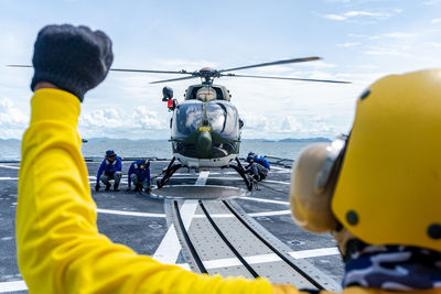 Rear view of yellow flying by sea against sky