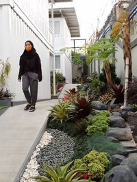 Full length of woman on footpath against building