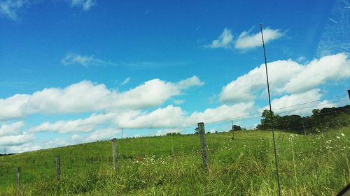 Scenic view of grassy field against cloudy sky