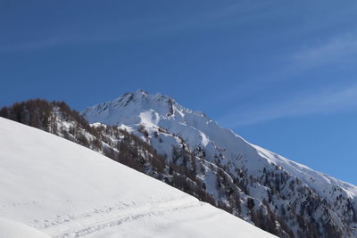 Snow covered mountain against blue sky