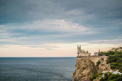 Scenic view of sea by building against sky