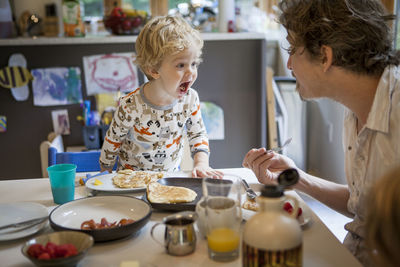 Father and son playing at dinning table in home