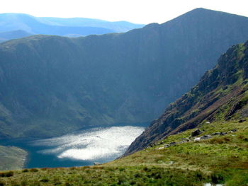 Scenic view of sea and mountains against sky