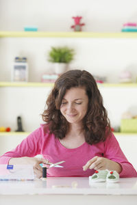 Portrait of a smiling young woman sitting on table