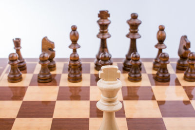 High angle view of chess pieces on board against gray background