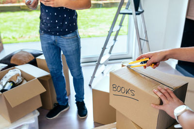 Couple opening box while standing at home