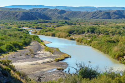 Scenic view of river amidst mountains against sky