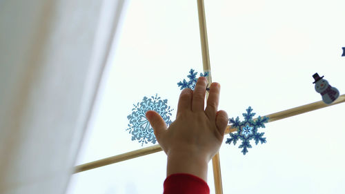 Close-up, people decorate the window in the house with christmas decorations, stickers. 