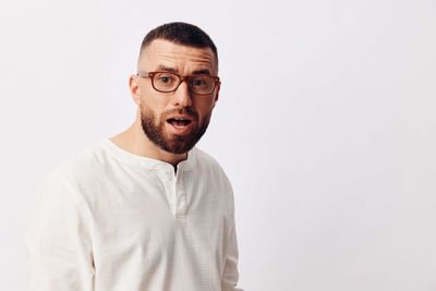 Portrait of young man standing against white background